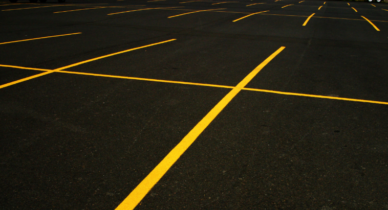 Empty asphalt parking lot with yellow lines